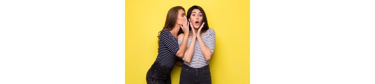 Two women whispering marketing secrets involving promotional lapel pins.
