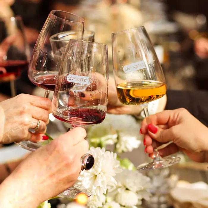 People celebrate a dinner party with custom logo glassware.