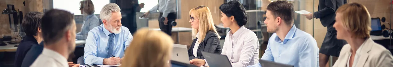 Professional people at a meeting using custom notebooks and pens at a meeting in Toronto.